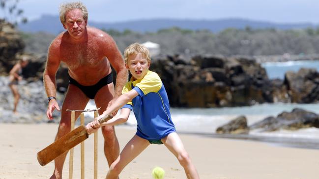 Holiday beach cricket at Little Cove, Noosa. Giles Evans-Barns, 8, of Brisbane, bats against his brother Augustus, 11, while John Kearney, of Sydney, plays the wicket keeper. Picture: Che Chapman