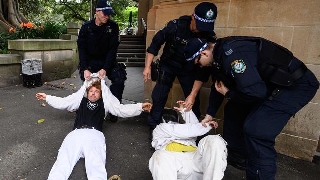 Police Officers drag activists from Extinction Rebellion out of the road in Elizabeth Street as they attempted to block traffic during a protest in Sydney. Picture: AAP Image/James Gourley