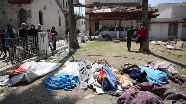 Palestinians look at covered bodies at Gaza's Baptist Hospital. Picture: AFP