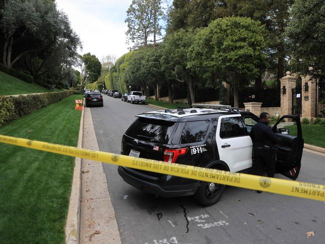 Police cars are seen behind caution tape outside the home of US producer and musician Sean 