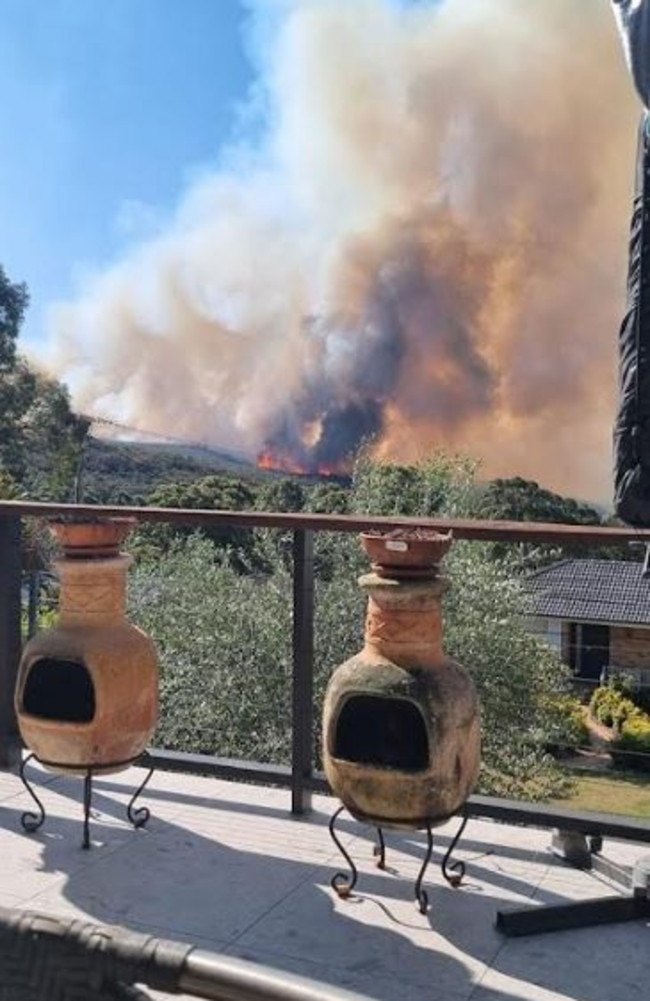 Firefighters have been stationed along Maybrook Ave and Pinduro Pl as the blaze sweeps in through bushland from the southwest. Picture: Carol Barbero (from her verandah at Cromer Heights)