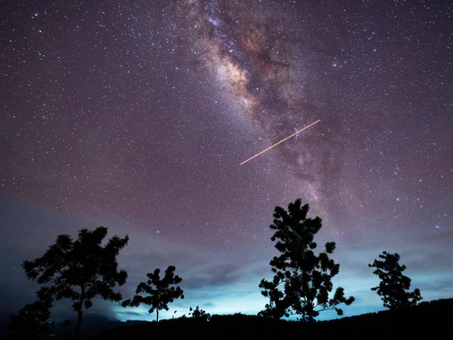 A flight-illuminated path and the Milky Way are appearing in the night sky during the Eta Aquarids meteor shower, which is peaking in Ratnapura, Sri Lanka, on May 5, 2024. The Eta Aquarids Meteor Shower is an annual event caused by Earth passing through debris left behind by Halley's Comet. Named after the constellation Aquarius, these meteors are streaking across the sky at high speeds, creating a dazzling display of shooting stars. Best observed in the predawn hours away from city lights, it is a mesmerizing celestial event cherished by skywatchers worldwide. (Photo by Thilina Kaluthotage/NurPhoto via Getty Images)