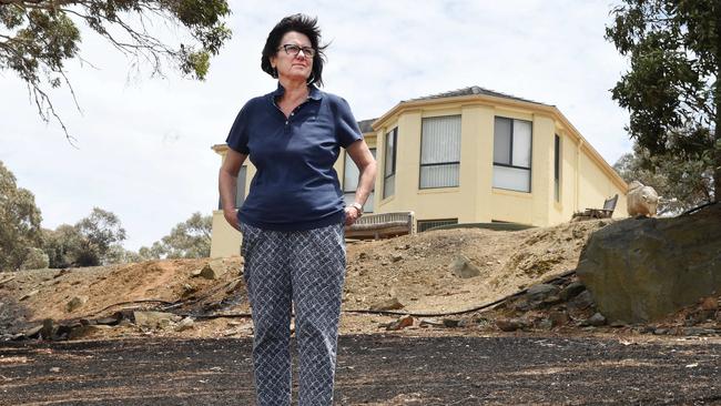 Susan Jeanes standing on her blackened property with her untouched house in the background. Picture Roger Wyman