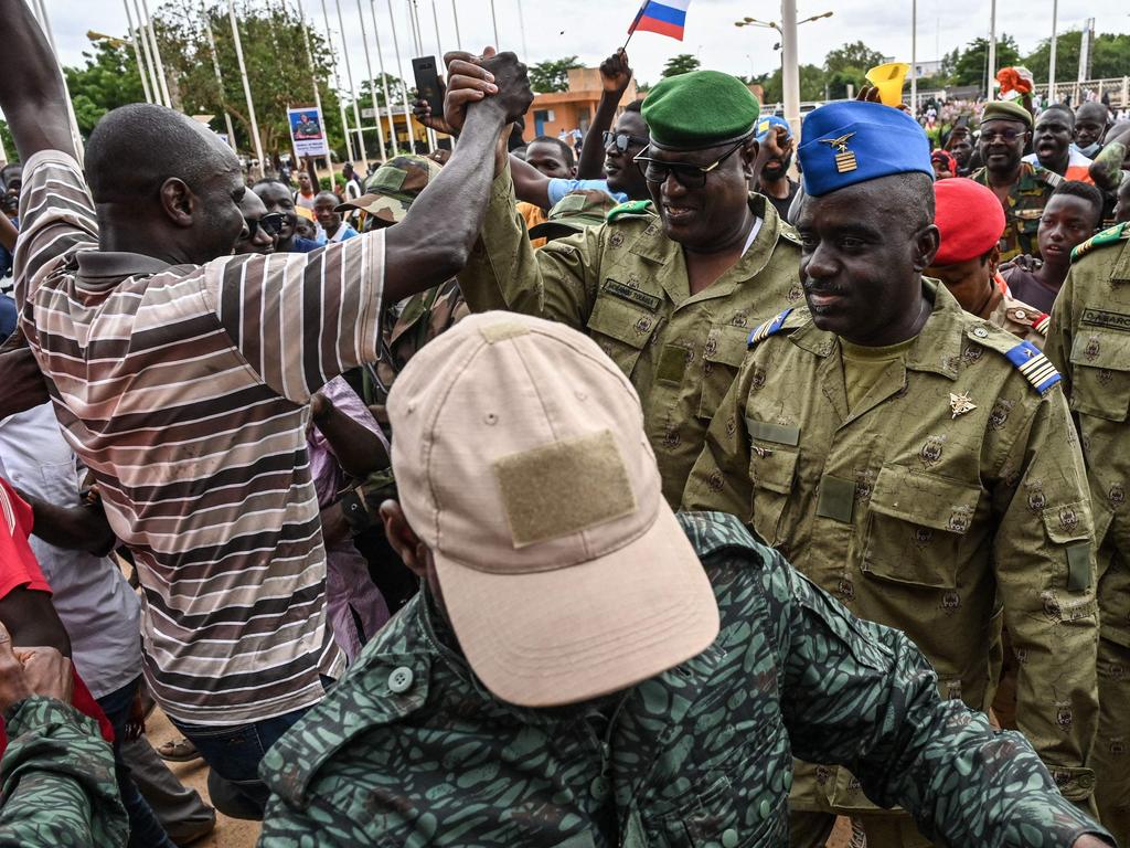 Niger's National Council for the safeguard of the Homeland (CNSP) Colonel-Major Amadou Abdramane (C), General Mohamed Toumba (C-L) and Colonel Ousmane Abarchi (R) are greeted by supporters.