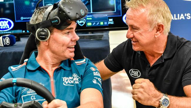 Craig Lowndes (left) on a Supercars racing simulator, and Russell Ingall in Townsville on Wednesday.