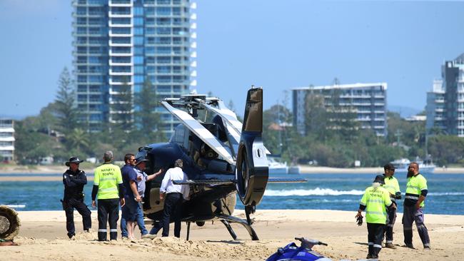 Aircrash investigators and staff from Harvey Towing look over the crash site for more debris and inspect one of the Sea World Helicopters involved in the collision. Picture: NewsWire / David Clark