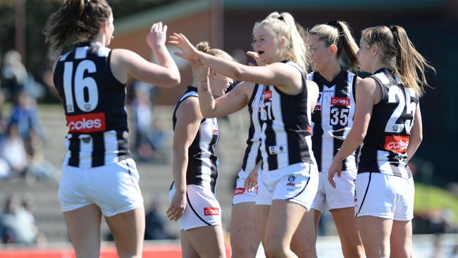 Collingwood VFLW players celebrate a goal last season.