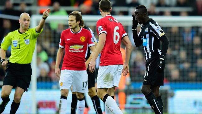 Papiss Cisse clears his face as Jonny Evans looks on.