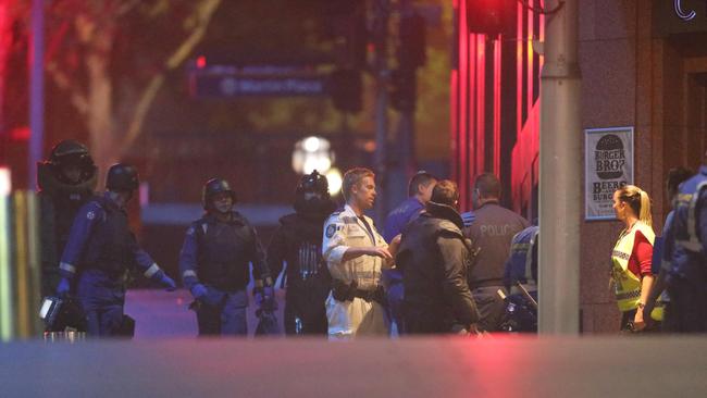 Police survey the scene of the siege shortly after it ended in December 2014. Picture: Bill Hearne