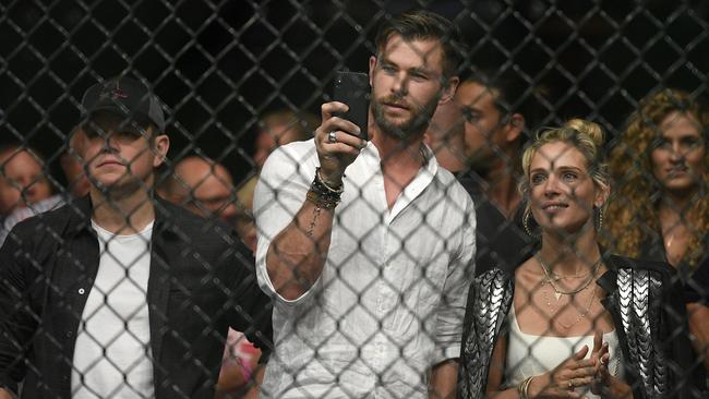 Matt Damon, Chris Hemsworth and Elsa Pataky watch Israel Adesanya and Anderson Silva during their UFC234 middleweight bout. Picture: AP Photo/Andy Brownbill