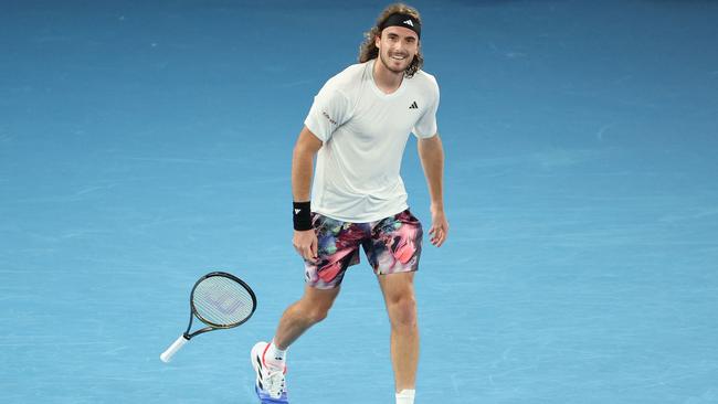 Stefanos Tsitsipas drops his racket after winning.