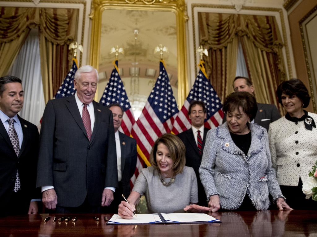 House Speaker Nancy Pelosi of Calif., centre, accompanied by politicianss, signs a deal to reopen the government on in Washington. Picture: AP Photo/Andrew Harnik