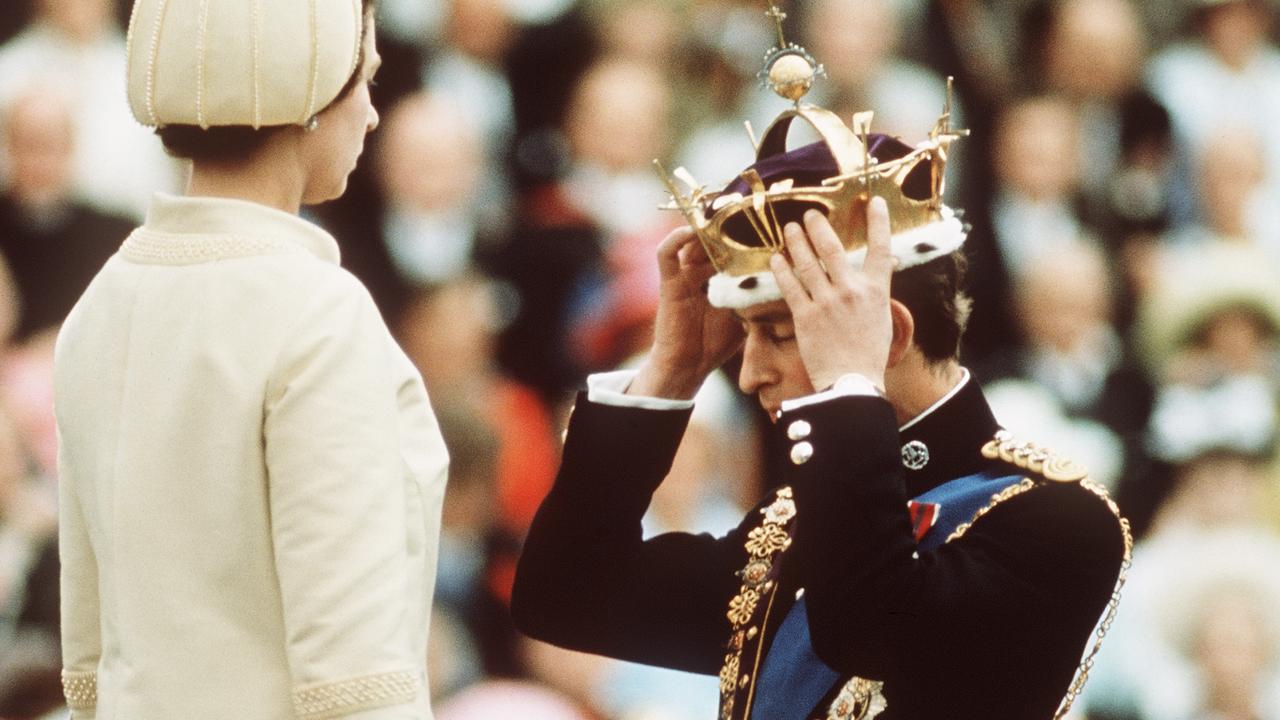 The then Prince Charles kneels before Queen Elizabeth as she crowns him Prince of Wales at the Investiture at Caernarvon Castle in 1969. Picture: Anwar Hussein/Getty Images