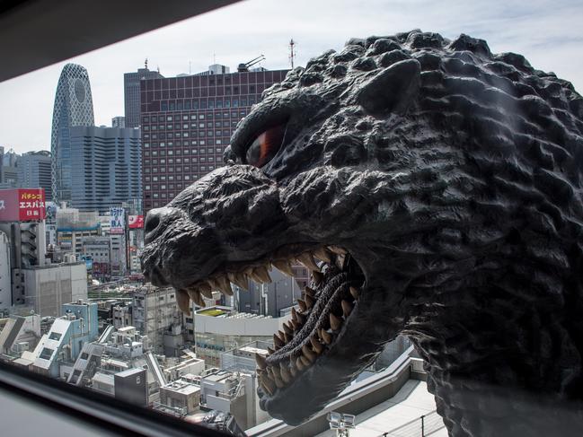 TOKYO, JAPAN - APRIL 15: A 12 meter tall Godzilla replica head is seen through a ninth floor hotel room window at the Hotel Gracery Shinjuku on April 15, 2015 in Tokyo, Japan. The Godzilla replica, based on the original 1954 film is the main attraction of a new commercial complex containing a movie theatre, hotel and restaurants situated in the Kabukicho, red light district of Shinjuku and will be opened on April 17th. Along with the replica head the hotel also has six Godzilla view rooms with windows looking directly onto Godzilla, and one Godzilla themed room containing a man-sized Godzilla statue as well as a large Godzilla claw over the beds. (Photo by Chris McGrath/Getty Images)