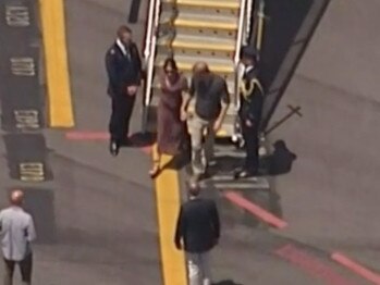 Prince Harry and Meghan hold hands as they arrive at Hervey Bay Airport. Picture: Nine Network