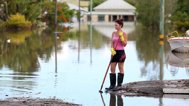 Residents clean up debris in their street as parts of southern Queensland experiences record flooding in the wake of Tropical Cyclone Oswald on January 30, 2013 in Bundaberg, Australia. (Photo by Chris Hyde/Getty Images)