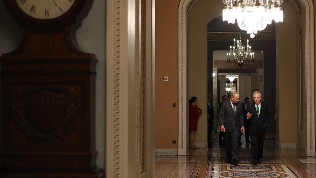 Senate Minority Leader Charles Schumer (left) and Senate Majority Leader Mitch McConnell (R) walk side-by-side to the Senate Chamber in Washington, DC overnight. (Image: AFP)