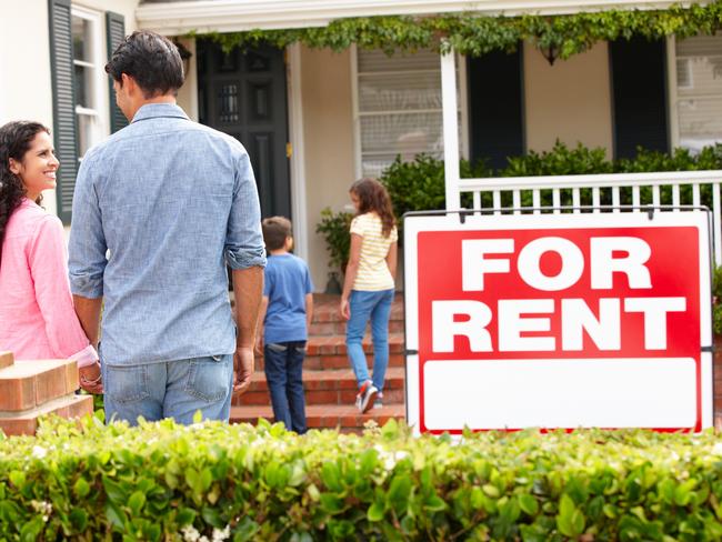 Hispanic family outside home for rent holding hands looking at each other happy