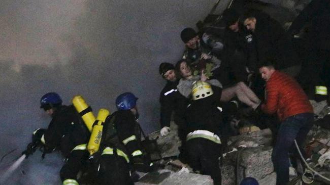 A woman found among debris of a residential building is carried out. Picture: Reuters