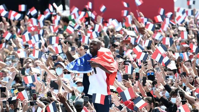 French judoka, Tokyo Olympics' heavyweight bronze medallist and mixed team gold medallist, Teddy Riner wrapped in a French flag cheers the crowd as he arrives for the transmission of the closing ceremony of the Tokyo 2020 Olympic Games, at the fan village of The Trocadero in front of The Eiffel Tower, in Paris. Picture: AFP