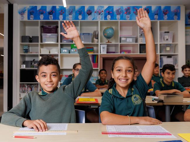 Marsden Road Public School students Yahya Alothmani, 11 and Ellie Geogiou, 11 raising their hand in class. Every student is sat in neat rows, eyes facing forward. Picture: David Swift