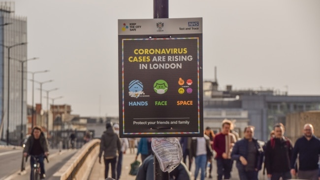 People walk past the 'Coronavirus Cases Are Rising In London' sign on London Bridge in February, 2021. Picture: Getty Images.