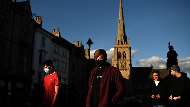 Young men walk in the evening sunlight in Durham, northeast England, this week. Picture: AFP