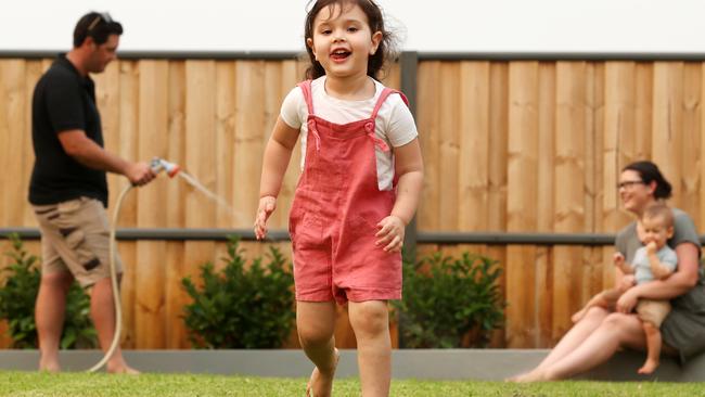 Ryan and Jessica Allen with their children Hudson, 1, and Ava, 3, using grey recycled water to water their garden at their home from the new water plant at The Gables Box Hill. Picture: Jonathan Ng