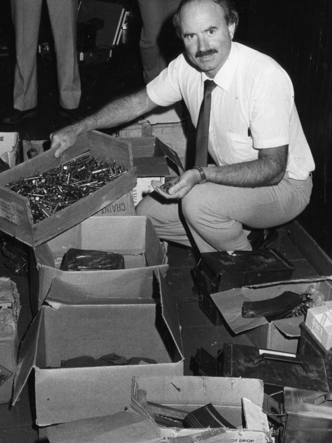 Sid Thomas with a weapons cache, likely linked to organised crime, found behind a false panel under a stairway to the toilets at the Old Hackney Cellars Restaurant, North Terrace, Hackney, in March 1985.