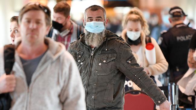 Passengers wear face masks as they arrive at Brisbane domestic airport. Picture: NCA NewsWire/Dan Peled