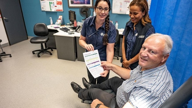Registered Nurses Monique Rauseo, left, and Nidia Dale, give the Minister for Health Steve Edgington a fact sheet on the flu vaccine. Picture: NT Health