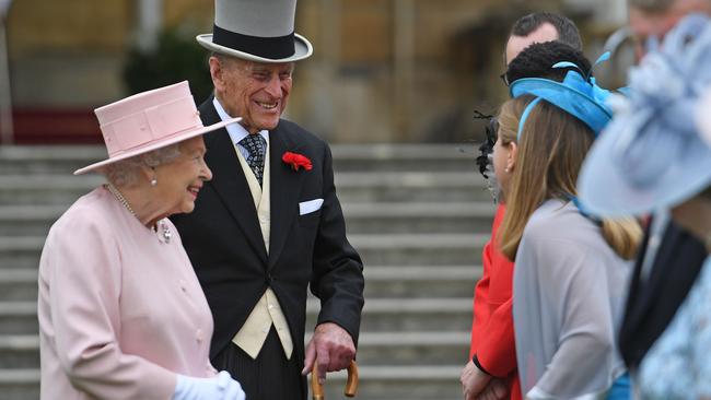 Britain's Queen Elizabeth II (L) and Britain's Prince Philip, Duke of Edinburgh (R) greet guests at a garden party at Buckingham Palace in London on May 16, 2017.  / AFP PHOTO / POOL / Victoria Jones