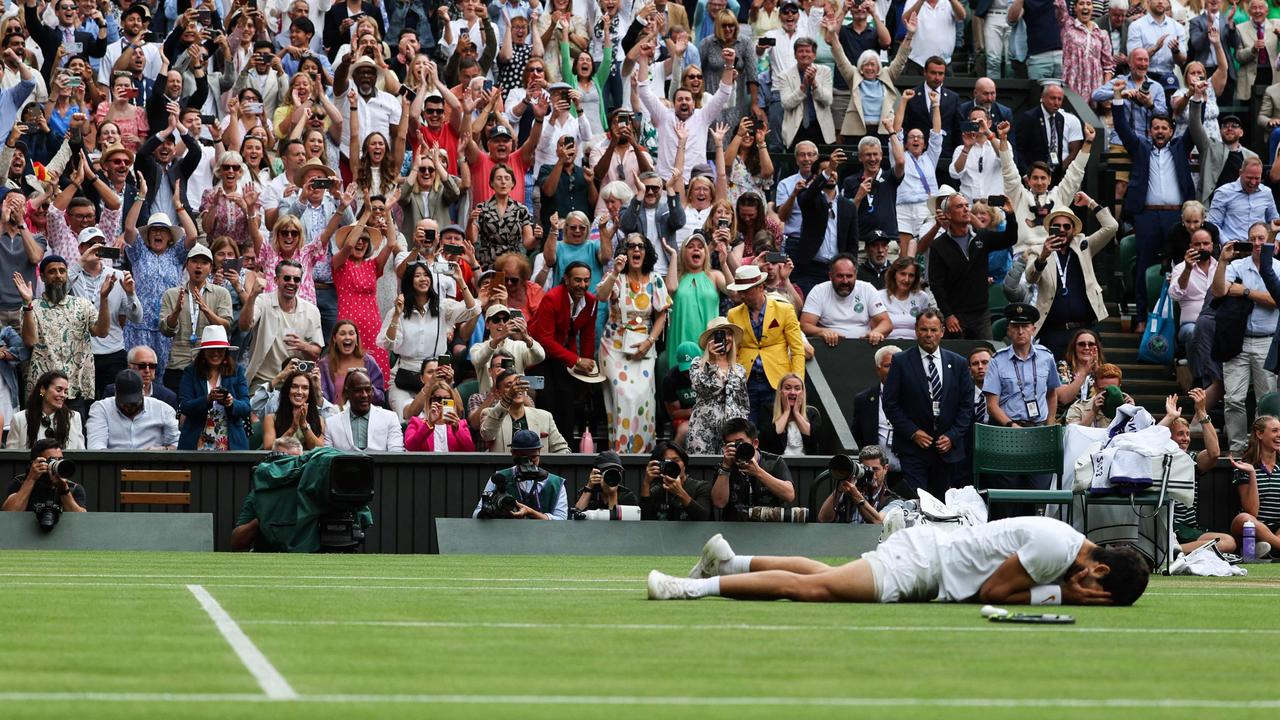 Carlos Alcaraz drops to the ground after winning match point. (Photo by Adrian DENNIS / AFP) / RESTRICTED TO EDITORIAL USE