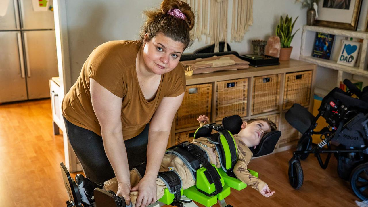 Katie Fattel helping her son Cassian into his standing support aide. Picture: Tom Huntley