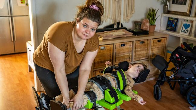 Katie Fattel helping her son Cassian into his standing support aide. Picture: Tom Huntley