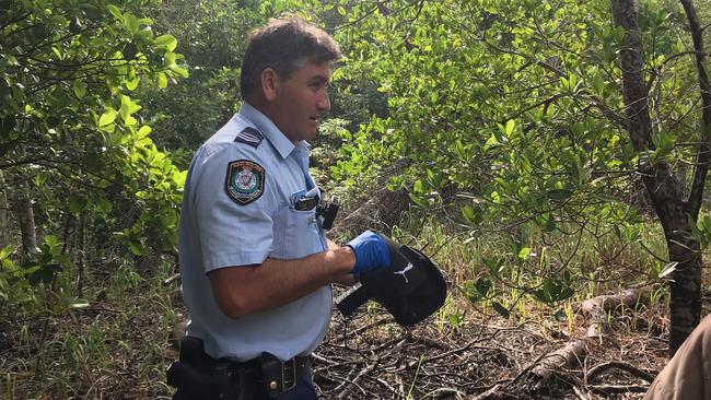 Constable Shane Lawson with the cap, similar to one owned by missing backpacker Theo Hayez. Picture: Jane Hanson