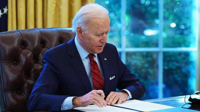 Joe Biden signs executive orders on health care, in the Oval Office. Picture: AFP.