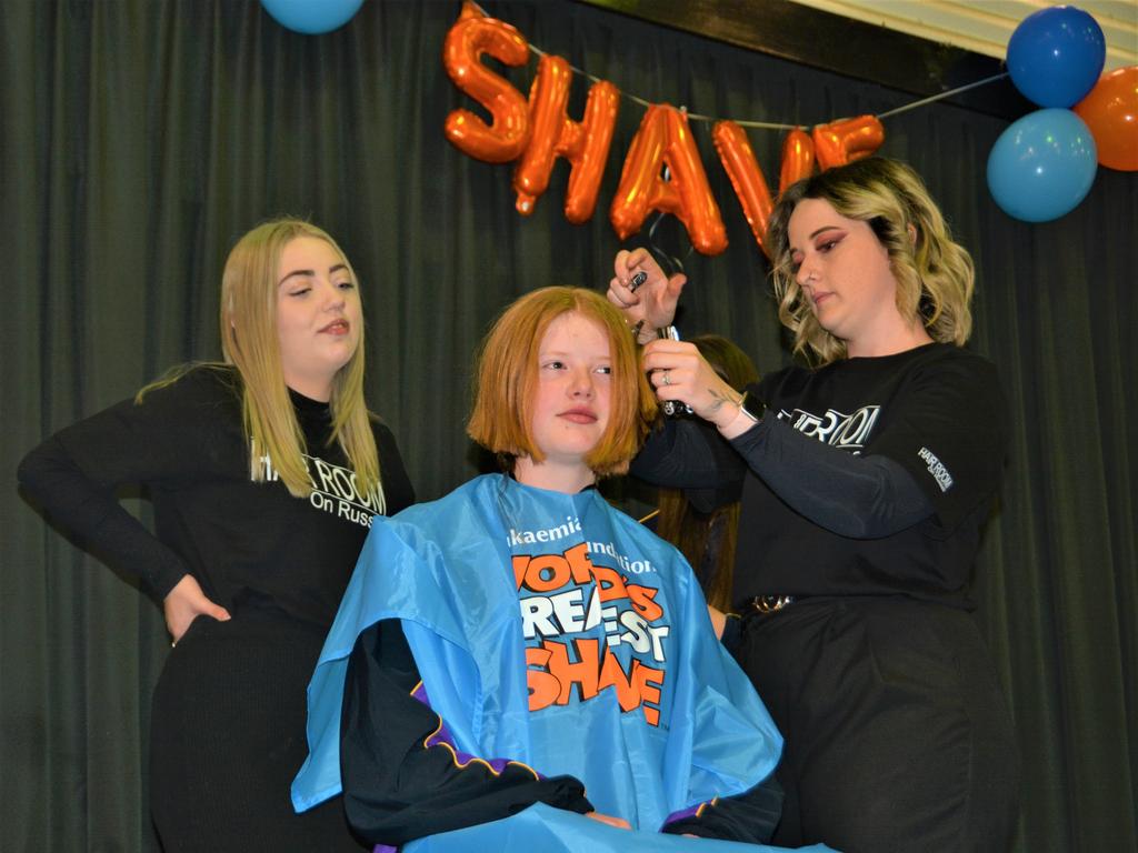 At the St Joseph's College 2023 World's Greatest Shave event is student Ellie Stagg having her hair cut by hairdressers (from left) Abbey McGaw and Natalie Schmidt from the Hair Room on Russell St. Picture: Rhylea Millar