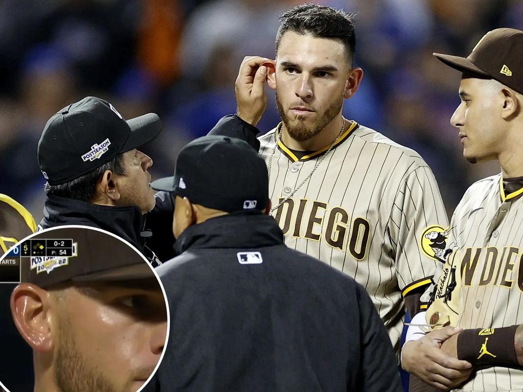 The umpire checks Padres pitcher Joe Musgrove's ear for a foreign substance.