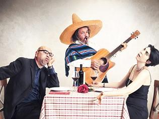 bored couple at dinner oblyed to listen to a mexican musician