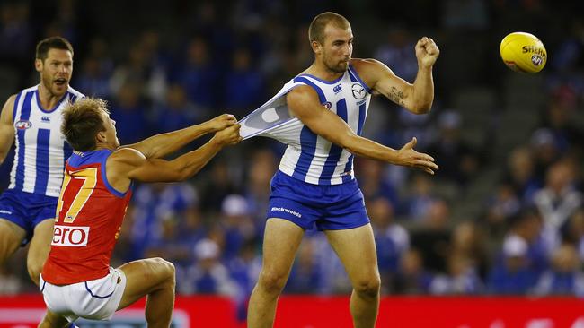 Lion Zac O’Brien trying to bring down Kangaroo Ben Cunnington. Picture: Michael Klein