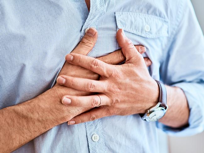 Shot of a unrecognizable man holding his chest in discomfort due to pain at home during the day