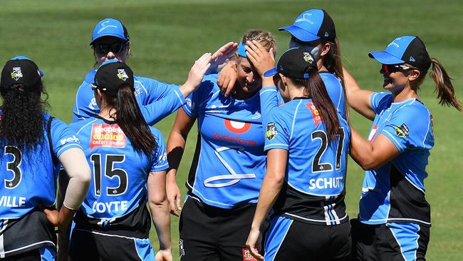 Adelaide Strikers players congratulate teammate Sophie Devine on Sunday. 