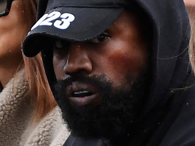 US rapper Kanye West (C), attends the Givenchy Spring-Summer 2023 fashion show during the Paris Womenswear Fashion Week, in Paris, on October 2, 2022. (Photo by JULIEN DE ROSA / AFP)