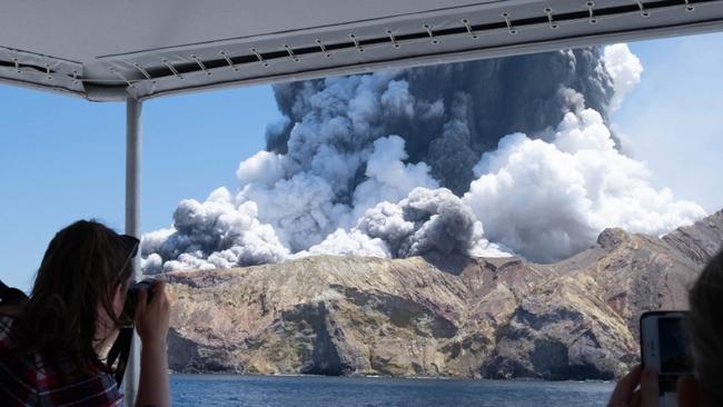 Tourists watch the volcano erupt. Picture: Michael Schade