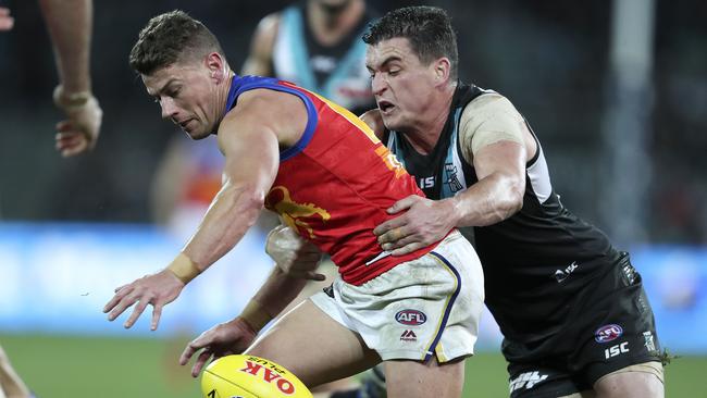 Brisbane’s Dayne Zorko is chased by Power midfielder Tom Rockliff. Picture SARAH REED