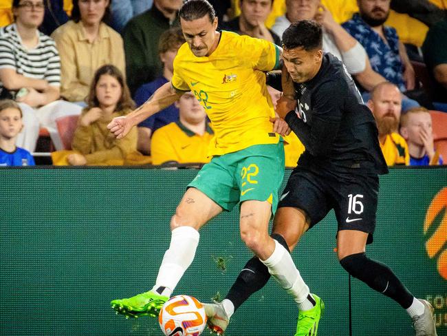 The Socceroos’ Jackson Irvine is tackled by New Zealand's Dane Ingham at Suncorp Stadium. Picture: Patrick Hamilton / AFP