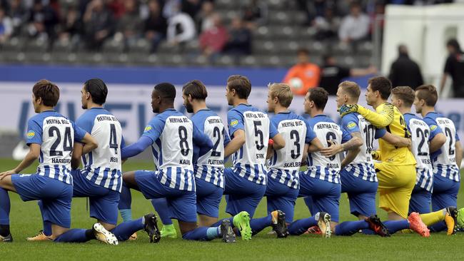 Players of Berlin kneel down prior to the Bundesliga match between Hertha BSC Berlin and FC Schalke 04.