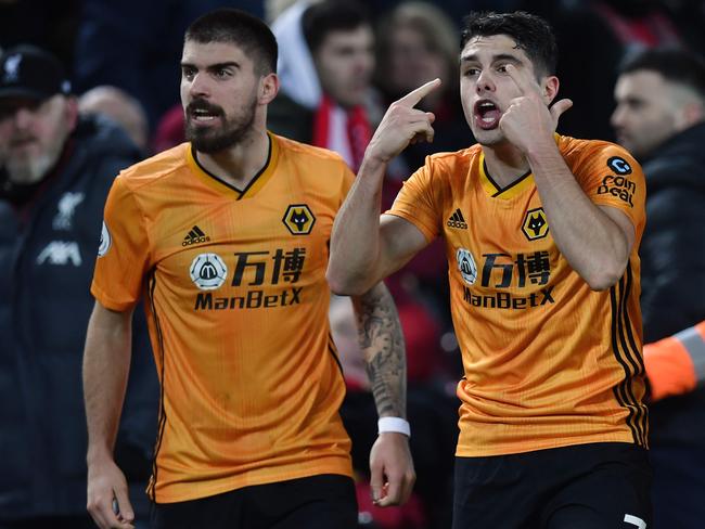 Wolverhampton Wanderers' Portuguese midfielder Pedro Neto (R) celebrates with team-mates after putting the ball in the Liverpool net, a goal that was subsequently ruled out by VAR due to an offside in the build up to it during the English Premier League football match between Liverpool and Wolverhampton Wanderers at Anfield in Liverpool, north west England, on December 29, 2019. (Photo by Paul ELLIS / AFP) / RESTRICTED TO EDITORIAL USE. No use with unauthorized audio, video, data, fixture lists, club/league logos or 'live' services. Online in-match use limited to 120 images. An additional 40 images may be used in extra time. No video emulation. Social media in-match use limited to 120 images. An additional 40 images may be used in extra time. No use in betting publications, games or single club/league/player publications. /