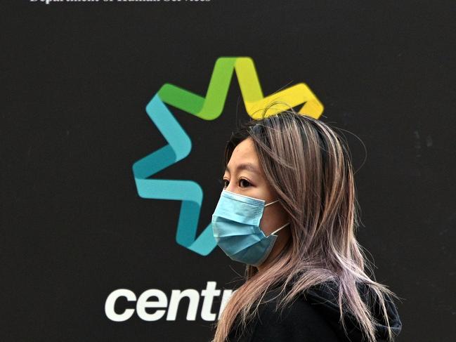 A woman waits in a queue to receive benefit payouts, including unemployment and small business support, at a Centerlink payment centre in downtown Sydney on April 14, 2020. - Australia's unemployment rate is expected to soar from 5.1 percent to 10 percent in the June quarter as the coronavirus fallout hits the economy, according to Treasury figures released on April 14. (Photo by Saeed KHAN / AFP)